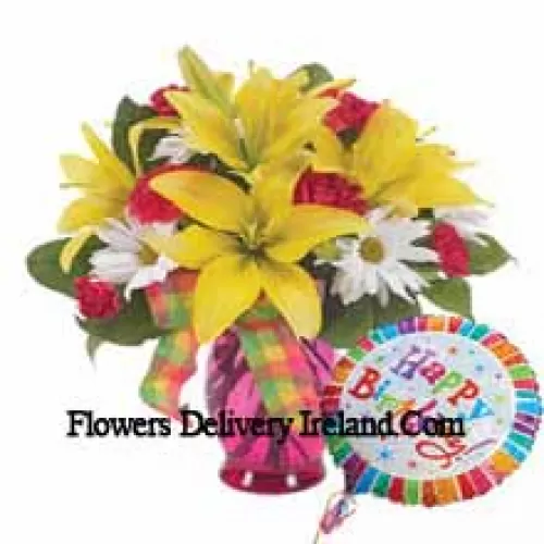 Red Carnations, Yellow Lilies And White Gerberas In A Glass Vase Accompanied With A "Birthday" Helium Balloon